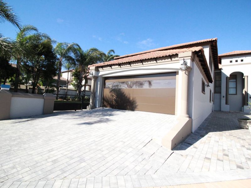 Front exterior view of the property featuring a paved driveway, a modern sectional garage door, and a tiled roof structure.