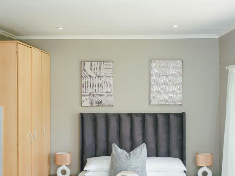 A well-maintained bedroom featuring a built-in wardrobe, neutral wall tones, and recessed ceiling lighting.