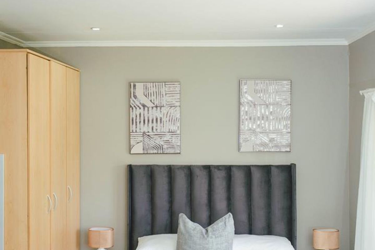 A well-maintained bedroom featuring a built-in wardrobe, neutral wall tones, and recessed ceiling lighting.