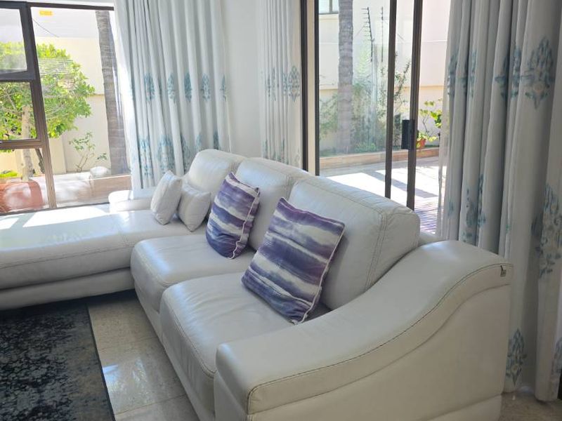 Bright living room featuring large sliding glass doors that provide natural light and direct access to the outdoor patio area.