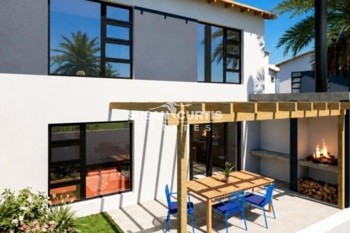 Rear exterior view of a modern townhouse featuring a covered timber pergola, built-in fireplace, and a private patio area.