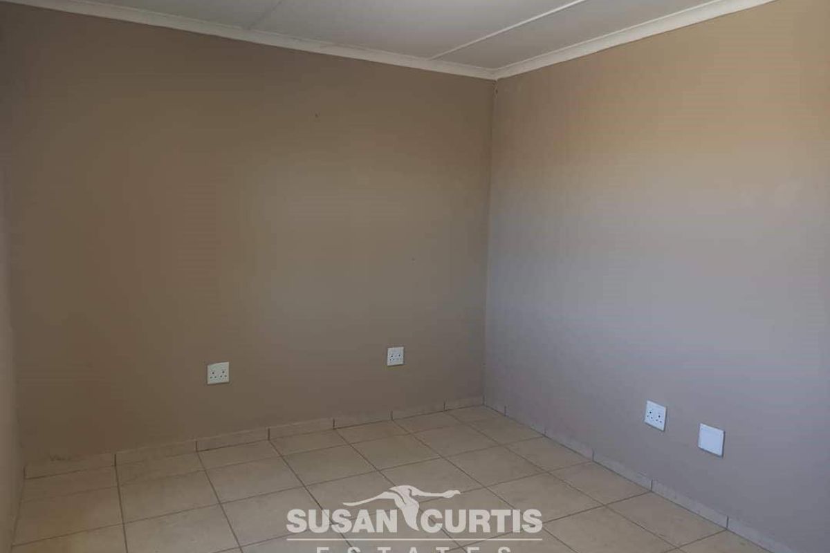 A vacant room featuring neutral wall paint, tiled flooring, and multiple electrical power points, suitable for use as a bedroom or office space.