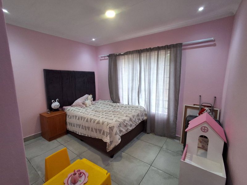 A bedroom featuring tiled flooring, recessed downlighting, and a window with curtain rod installation.