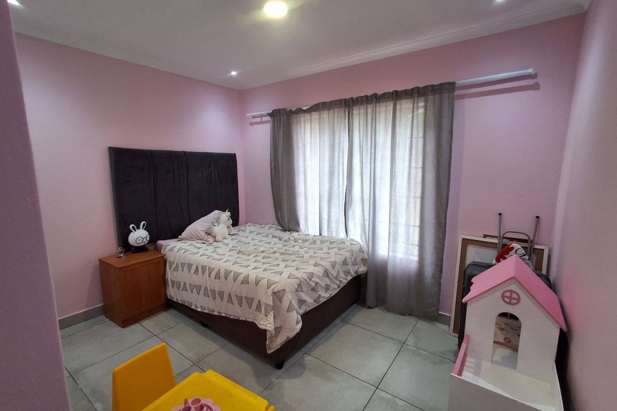A bedroom featuring tiled flooring, recessed downlighting, and a window with curtain rod installation.