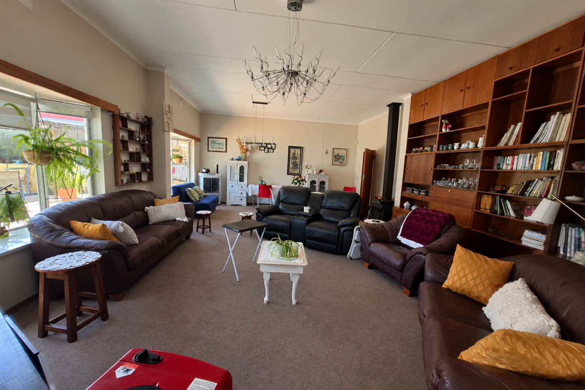 Spacious living room featuring a large built-in wooden bookshelf, a fireplace, and sliding glass doors that provide access to the outdoor area.