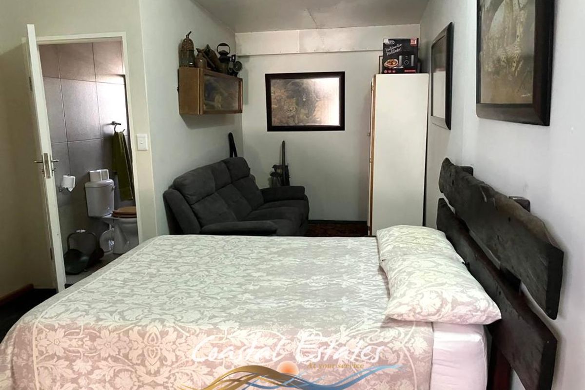 A bedroom featuring an en-suite bathroom, neutral wall tones, and a functional layout with direct access to the private bathroom facilities.
