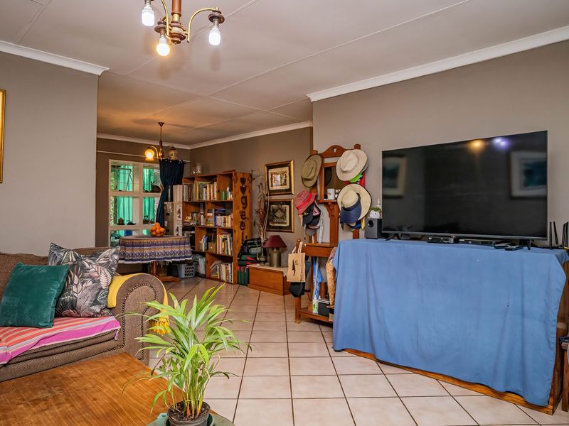 Open-plan living area featuring neutral wall tones, tiled flooring, and coved ceilings, providing a versatile space for lounge and dining arrangements.