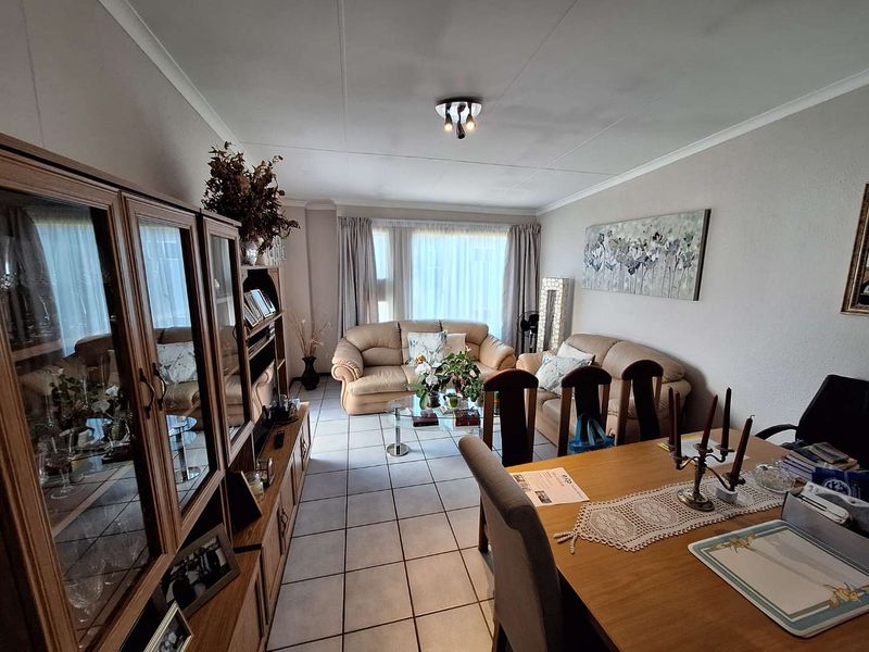 An open-plan living and dining area featuring tiled flooring and neutral wall finishes, providing a functional space for relaxation and meals.