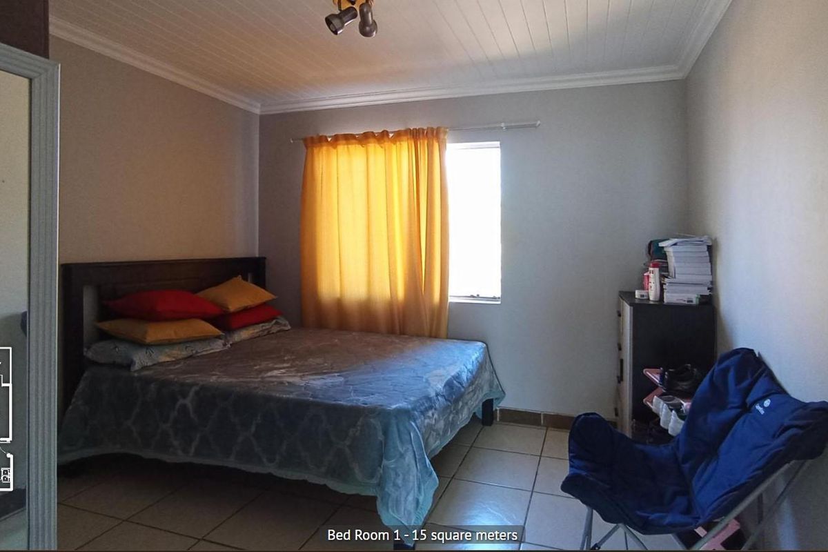 A bedroom featuring tiled flooring and a tongue-and-groove ceiling, providing a functional living space.