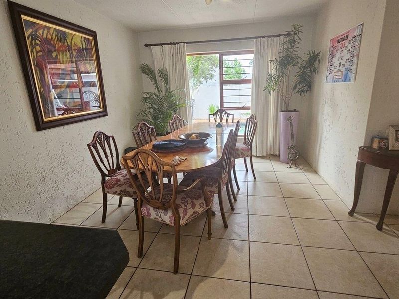 A dining room featuring tiled flooring and a sliding glass door providing access to the outdoor area.