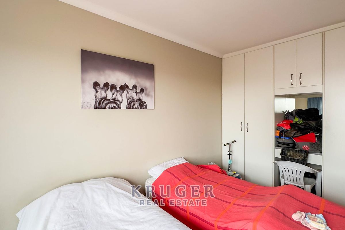 A bedroom featuring neutral wall tones and integrated built-in cupboards with a dedicated vanity section.