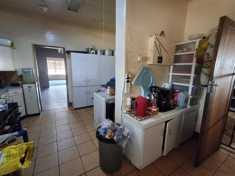 A functional kitchen area featuring tiled flooring and built-in cabinetry, offering potential for modernization and layout optimization.