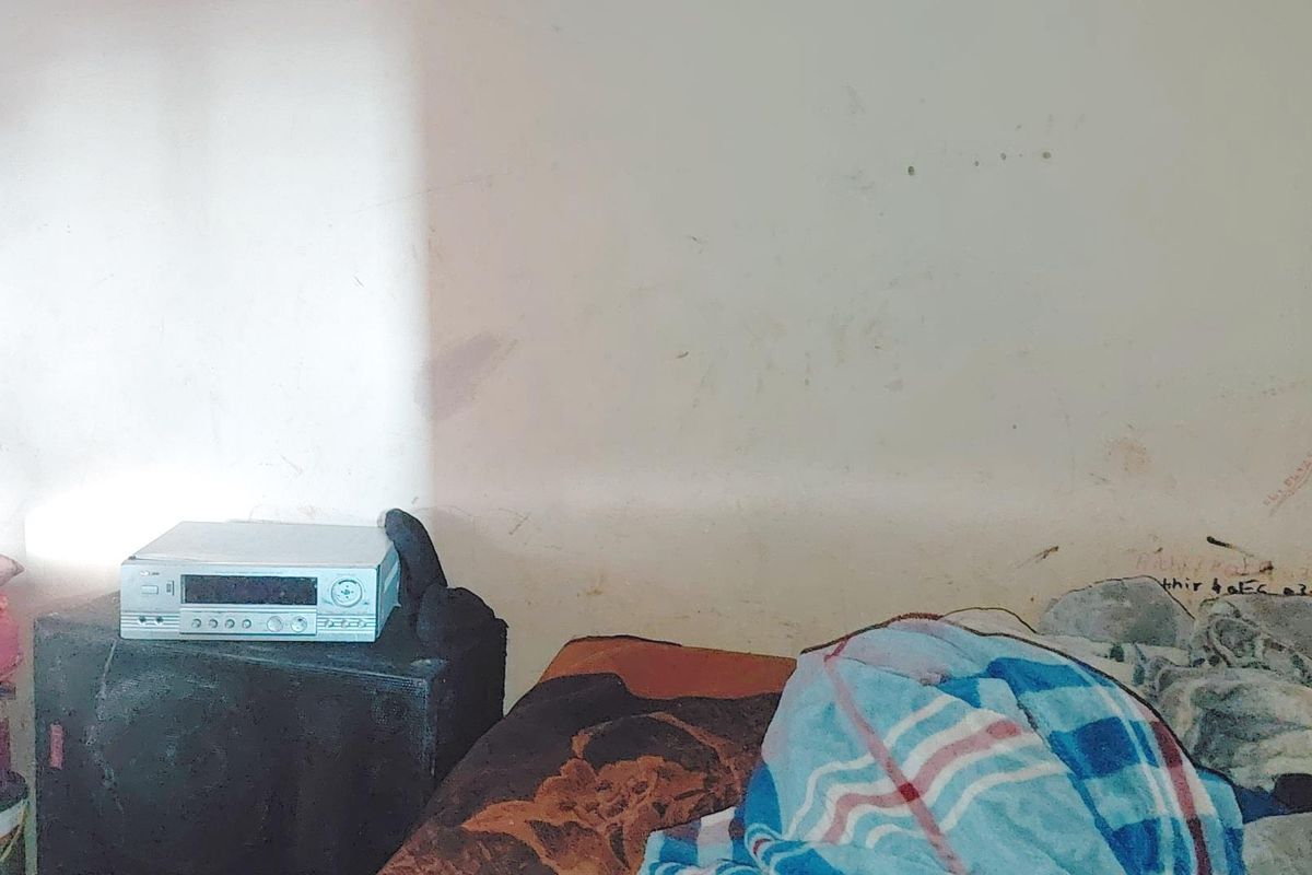 A bedroom interior showing significant wall staining and wear, requiring cosmetic attention and repainting to improve the overall condition of the space.