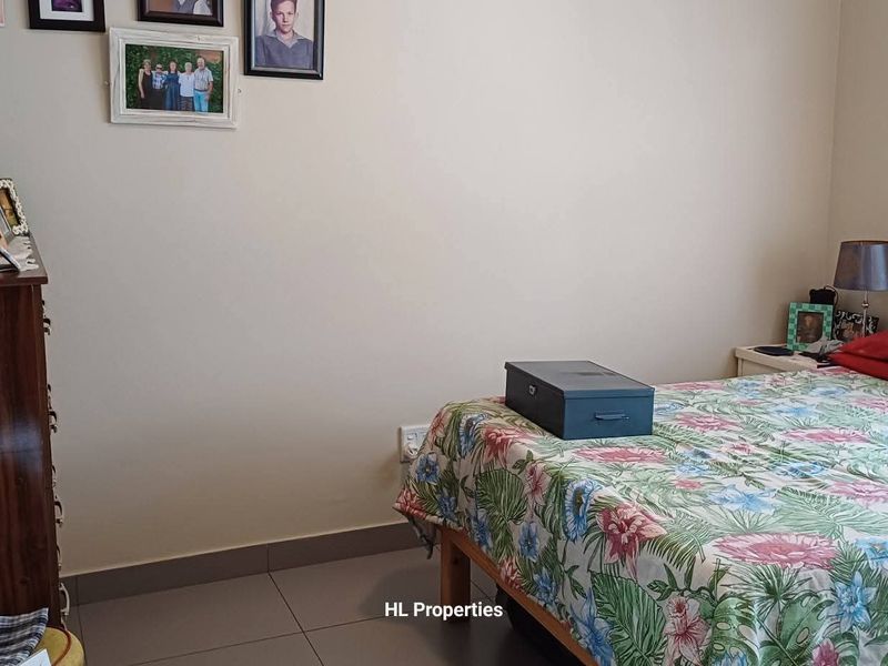 A standard bedroom featuring tiled flooring and a window, providing a functional living space.