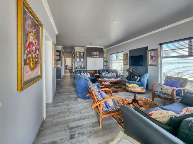 Spacious open-plan living area featuring modern tiled flooring, recessed downlighting, and neutral wall finishes, providing a versatile space for relaxation.