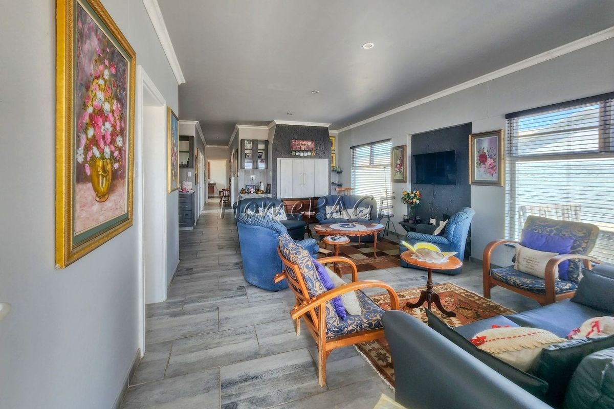Spacious open-plan living area featuring modern tiled flooring, recessed downlighting, and neutral wall finishes, providing a versatile space for relaxation.