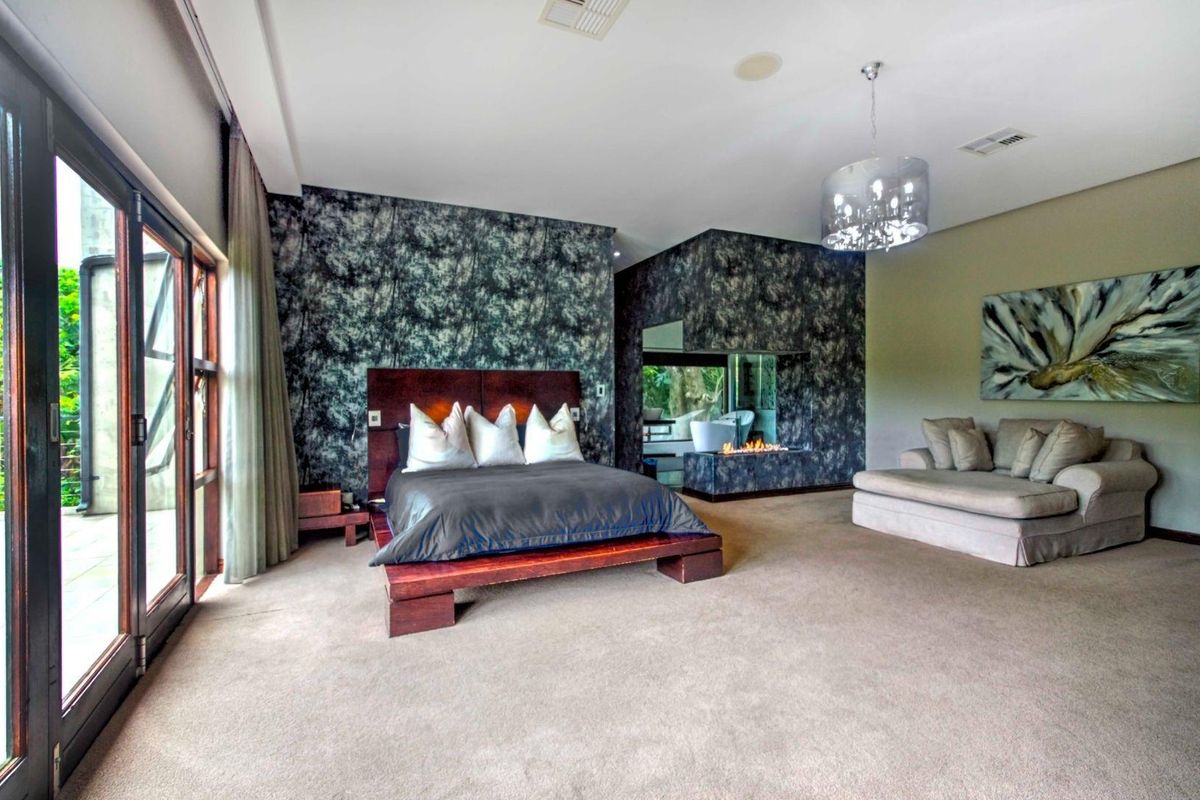 Spacious bedroom featuring a built-in fireplace, textured feature walls, and large glass sliding doors providing access to the outdoor area.