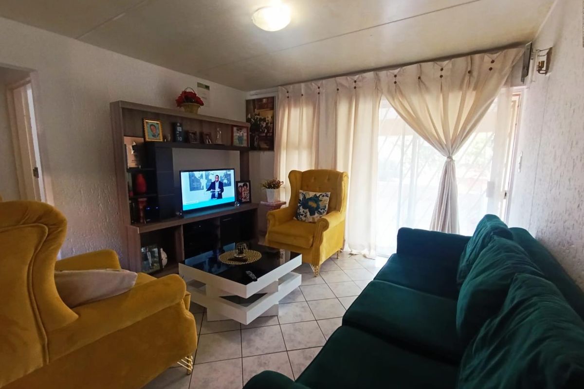 A comfortable living room featuring tiled flooring and sliding glass doors that provide access to the outdoor area.