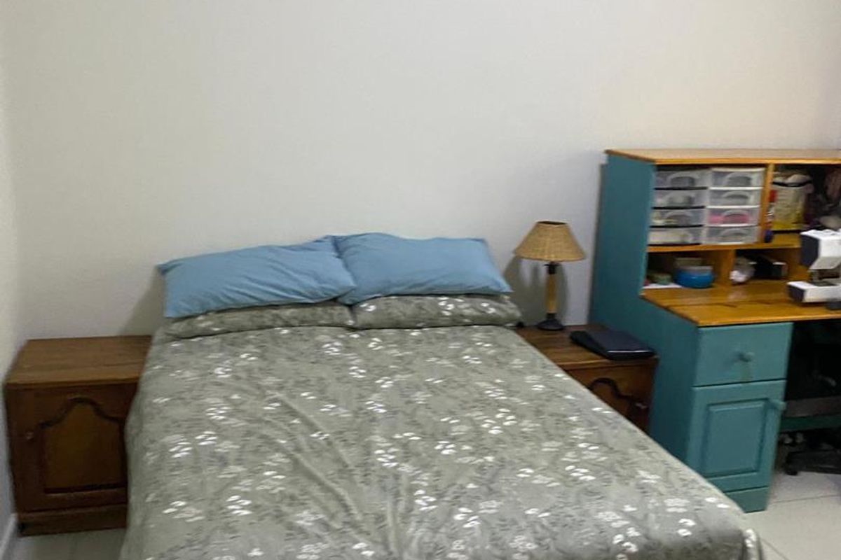 A functional bedroom featuring tiled flooring and neutral wall finishes, providing a simple and practical living space.