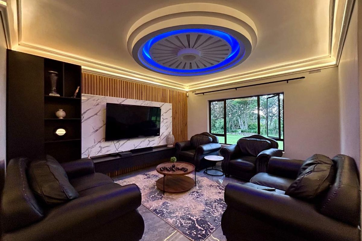 Modern living room featuring a striking circular recessed ceiling with integrated blue LED lighting, marble-look feature wall, and timber slat paneling.