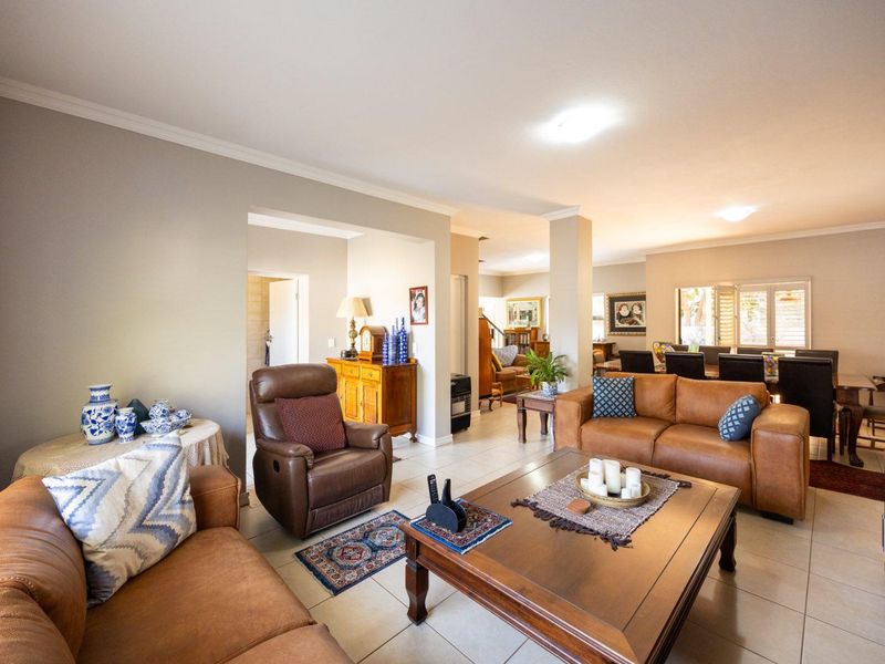 Spacious open-plan living and dining area featuring neutral wall tones, tiled flooring, and coved cornicing, creating a bright and functional family space.