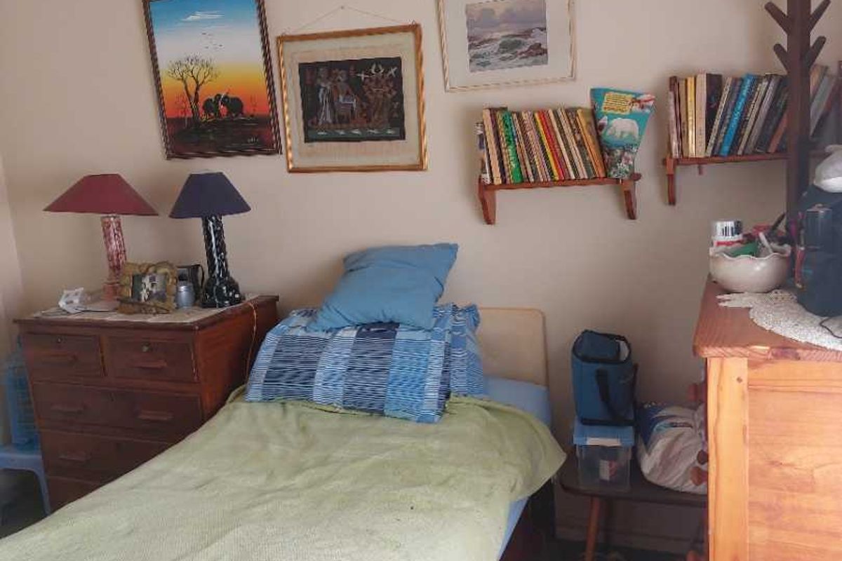 A standard bedroom featuring neutral wall finishes and carpeted flooring, providing a functional space for rest.