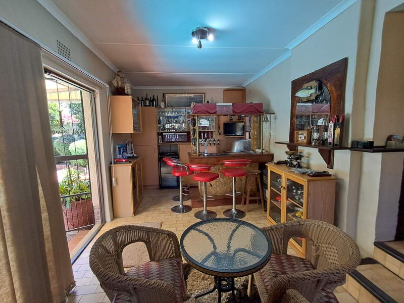 A dedicated home bar area featuring built-in cabinetry, a bar counter, and direct access to the outdoor patio through a sliding glass door.