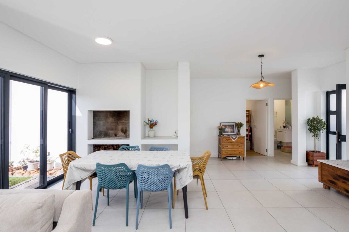 Spacious living area featuring tiled flooring, a built-in fireplace, and large sliding glass doors providing access to the exterior.
