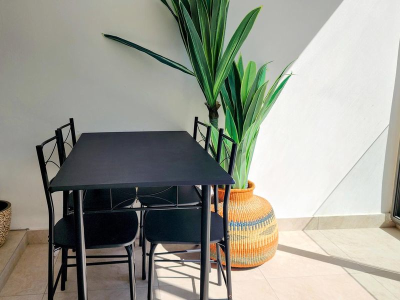 A bright, tiled balcony area featuring a sliding glass door, providing a clean and functional outdoor space.