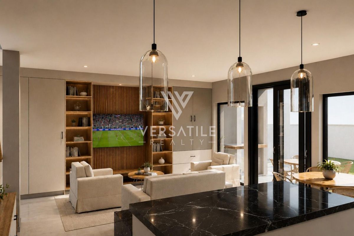 Modern open-plan living area featuring a sleek black marble kitchen island, custom built-in cabinetry, and seamless access to the outdoor patio through sliding glass doors.