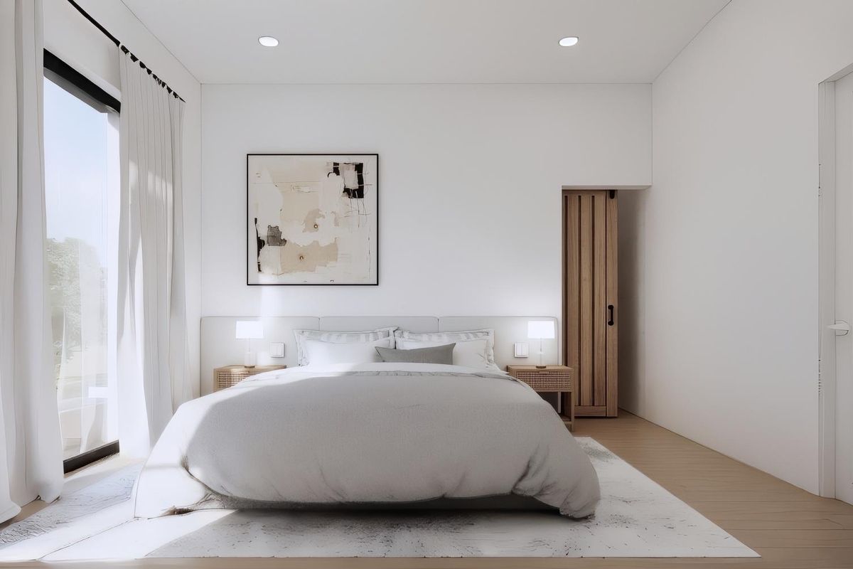 A bright, modern bedroom featuring light wood flooring, recessed lighting, and a sliding timber door, with large glass doors providing natural light.
