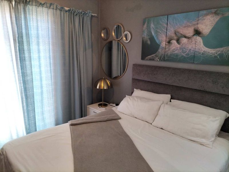 A well-maintained bedroom featuring neutral wall tones, soft window treatments, and a comfortable layout suitable for a primary or guest sleeping area.