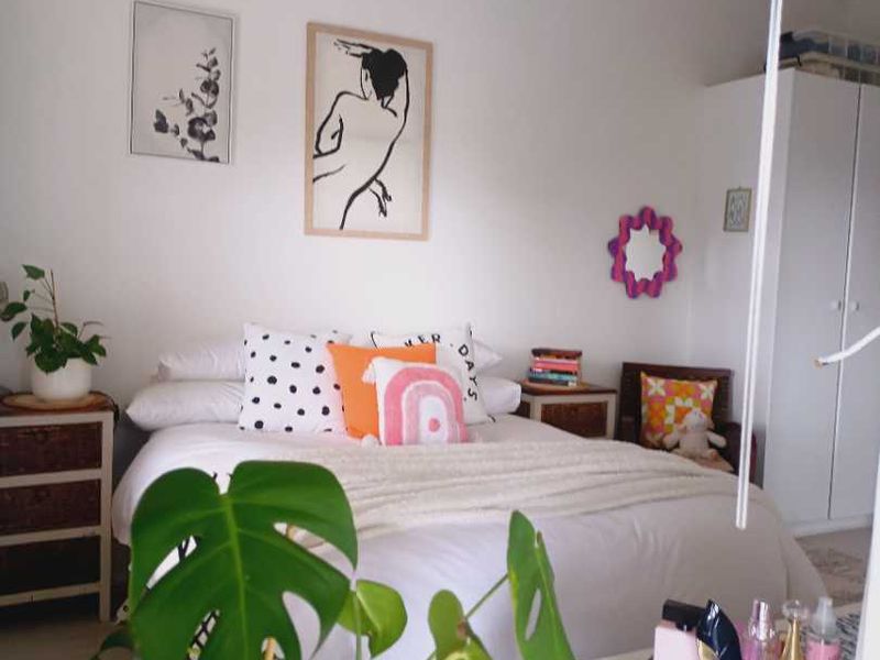 A cozy bedroom featuring a built-in wardrobe and neutral wall finishes, providing a functional and comfortable sleeping space.