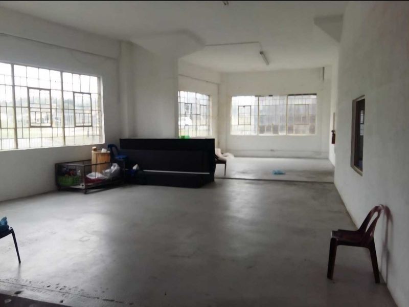 Spacious open-plan industrial unit featuring large steel-framed windows, concrete flooring, and ample natural light, suitable for various commercial or workshop applications.