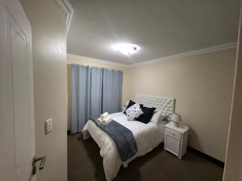 A cozy bedroom featuring crown molding, neutral wall finishes, and carpeted flooring, providing a comfortable and functional sleeping space.