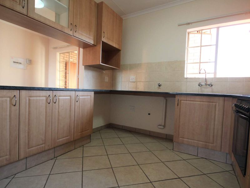 A functional kitchen featuring laminate cabinetry, granite countertops, tiled backsplash, and built-in oven, offering a clean and practical workspace.