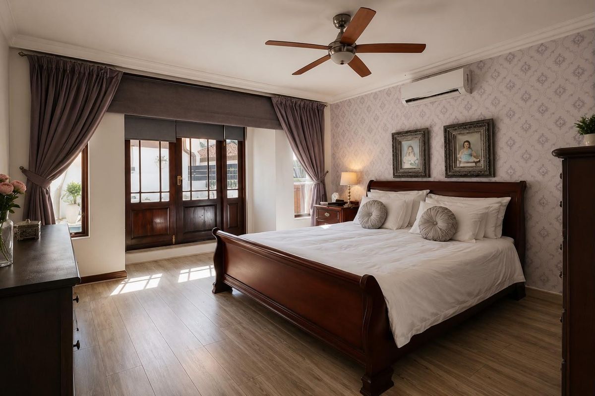 A well-maintained bedroom featuring laminate flooring, crown molding, a ceiling fan, and a split-system air conditioner, with direct access to an outdoor area.