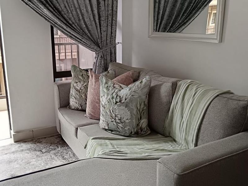 A cozy living room area featuring a sliding door with curtain tracks, providing access to an outdoor space.