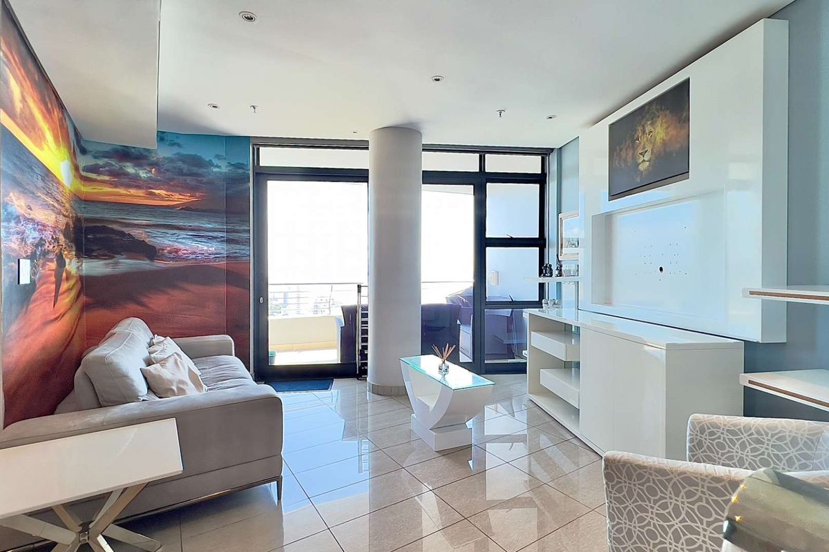 Modern living room featuring polished tile flooring, a built-in media console, and large sliding glass doors providing access to the balcony.