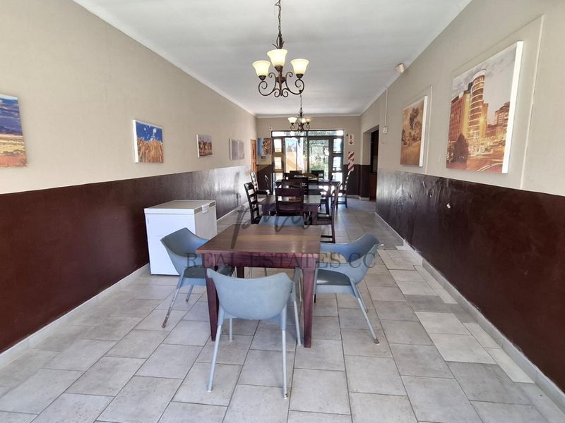 Spacious dining area featuring tiled flooring and a two-tone wall finish, providing a functional space for guest meals.
