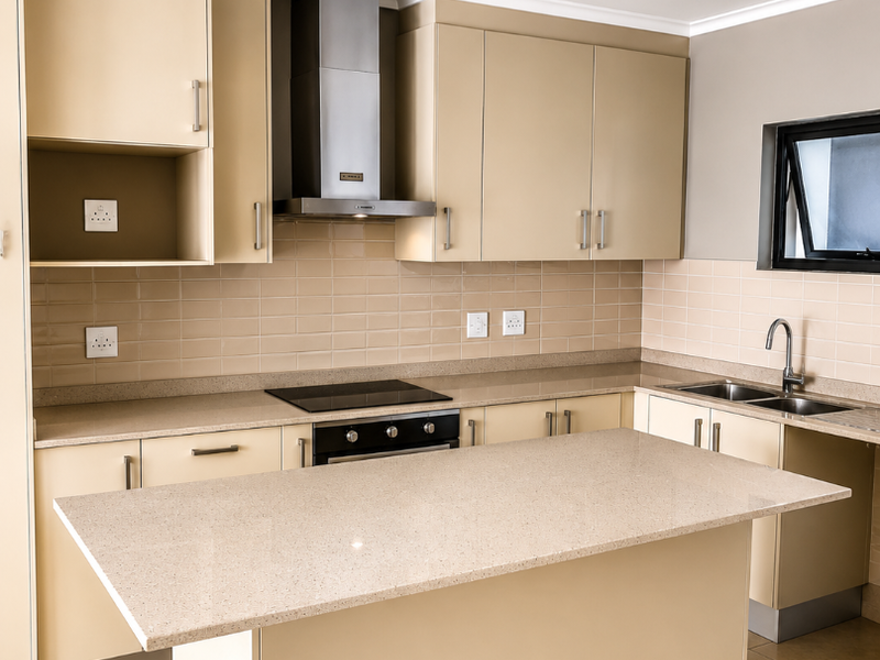 Modern kitchen featuring neutral-toned cabinetry, stone countertops, a central island, integrated appliances, and a tiled backsplash with a functional layout.