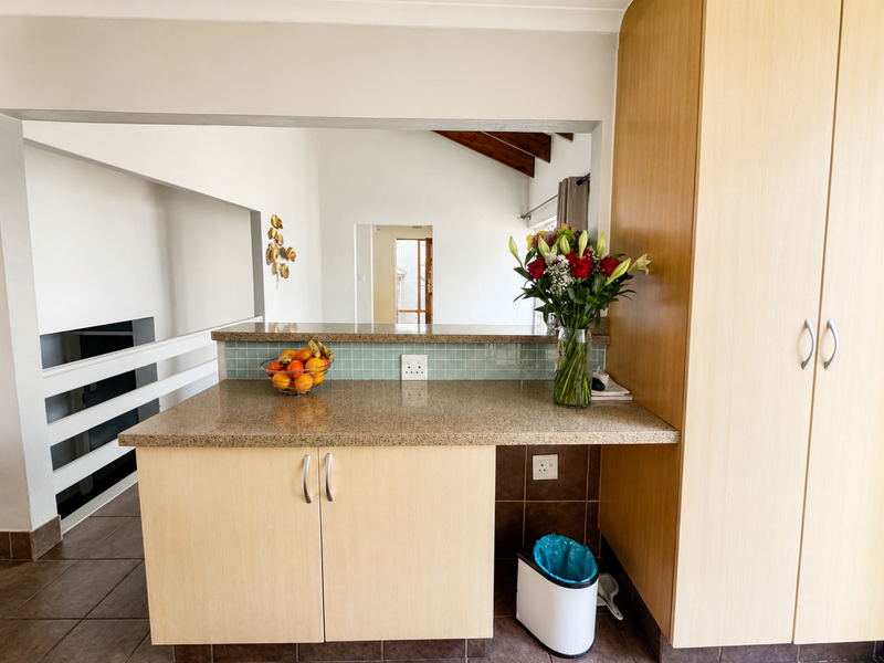 A functional kitchen area featuring light wood-finish cabinetry, granite countertops, and a mosaic tile backsplash, offering a clean and practical workspace.