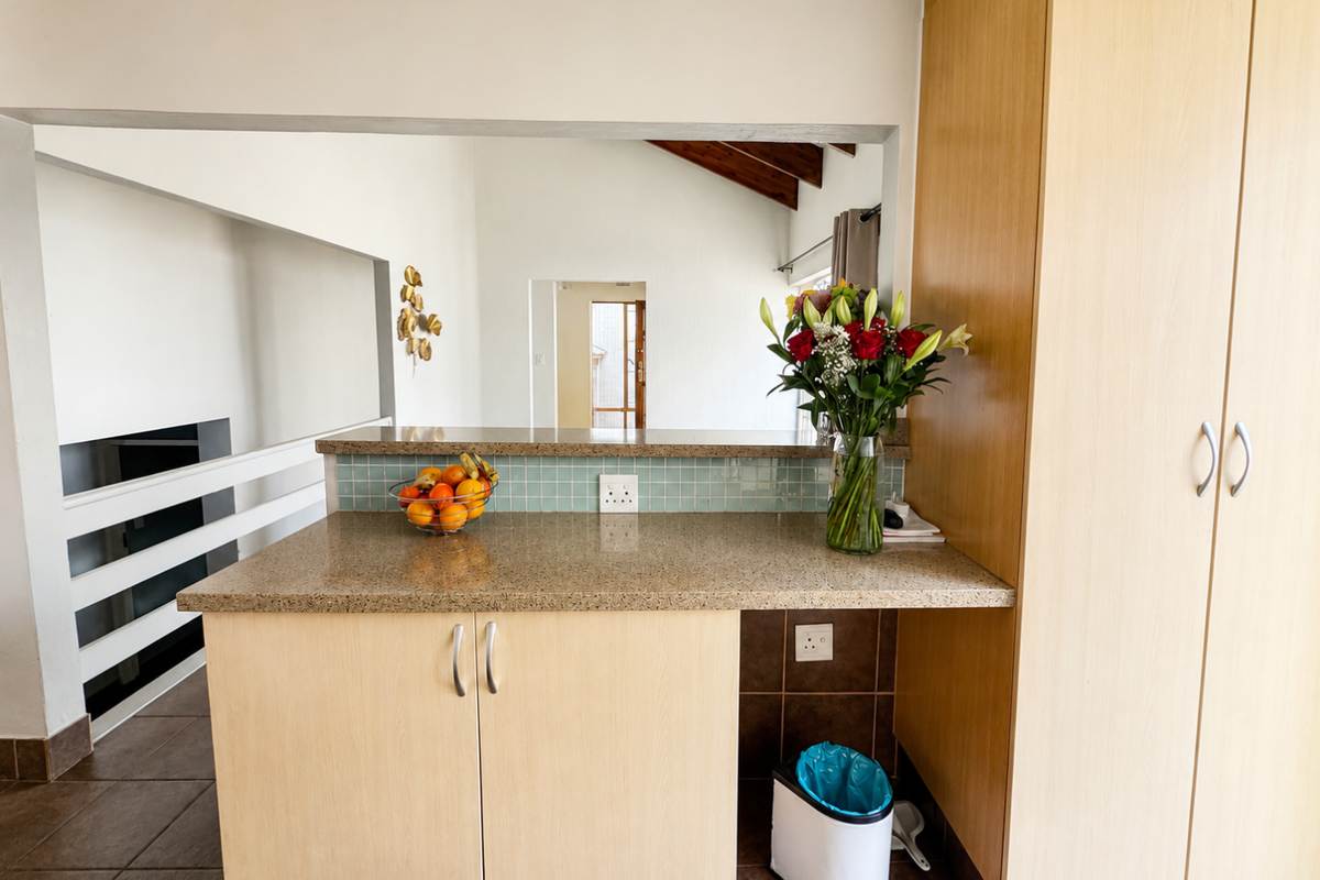 A functional kitchen area featuring light wood-finish cabinetry, granite countertops, and a mosaic tile backsplash, offering a clean and practical workspace.