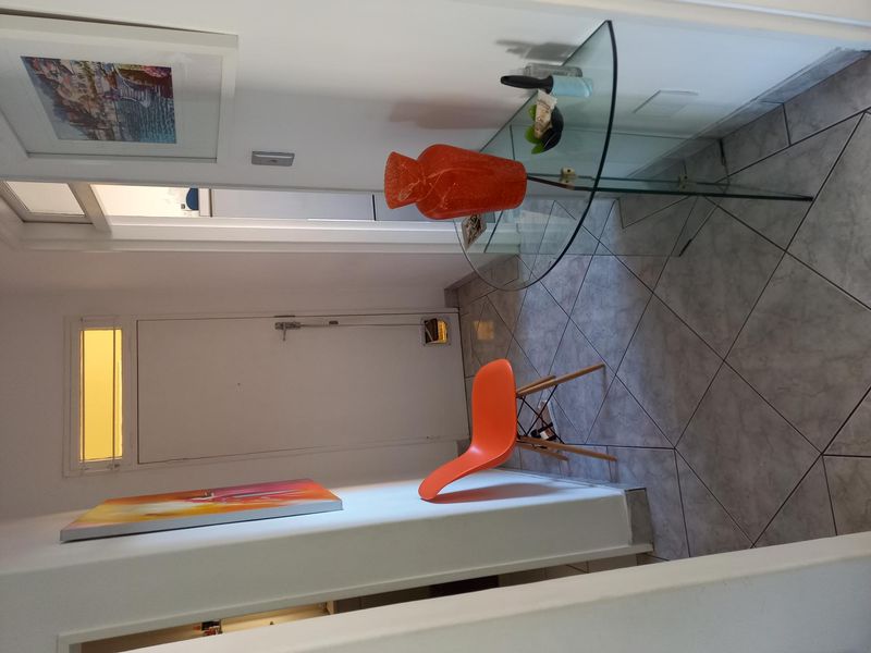 A functional apartment hallway featuring tiled flooring and a built-in pet door, providing access to adjacent living spaces.