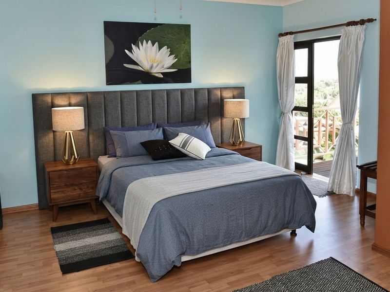 A well-maintained bedroom featuring laminate flooring and direct access to an outdoor balcony through a glass panel door.