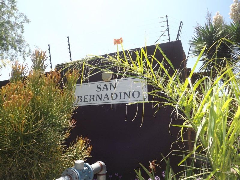 Entrance signage for San Bernadino complex featuring a secure boundary wall with installed electric fencing.