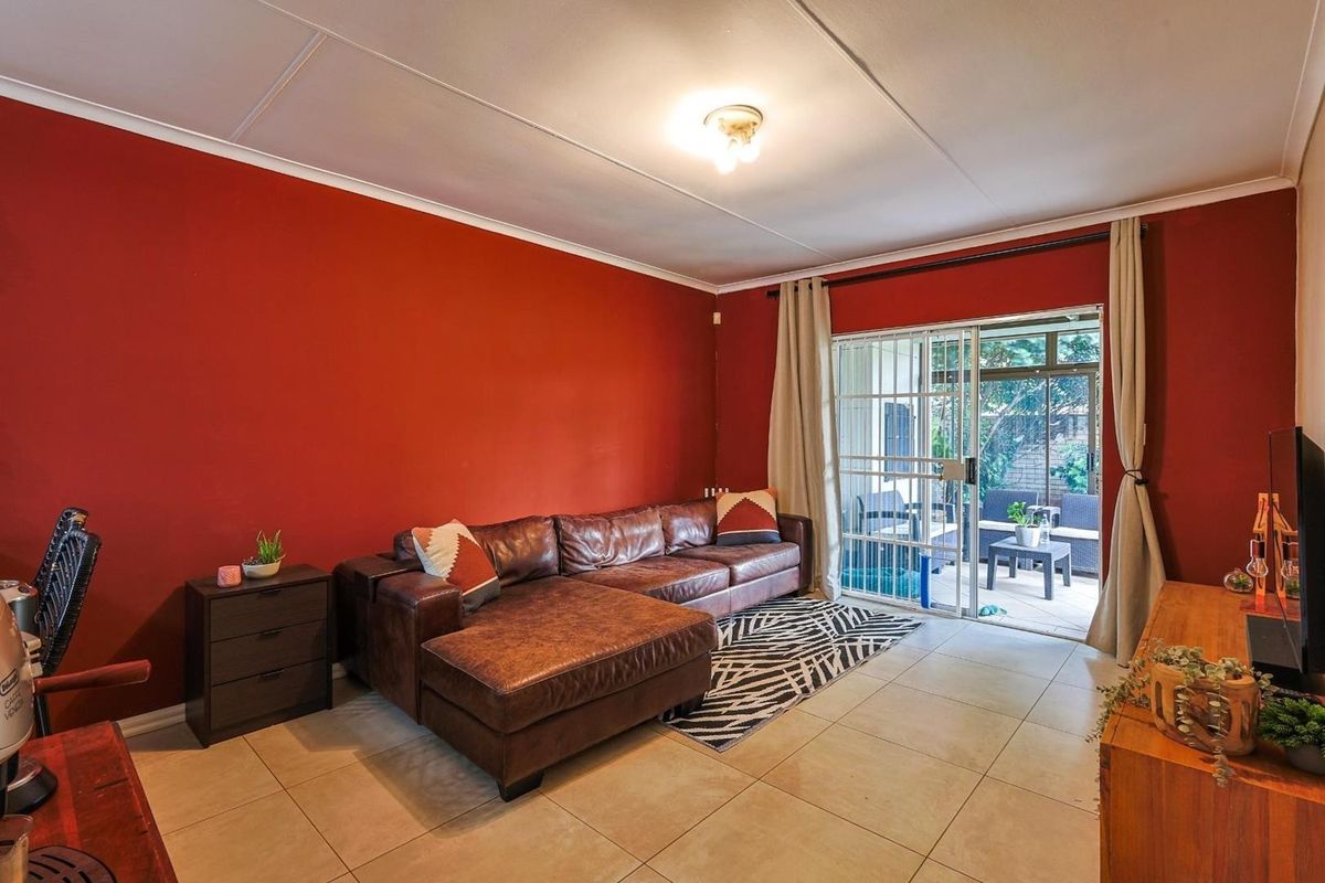Living room featuring tiled flooring and sliding glass doors providing direct access to an outdoor patio area.