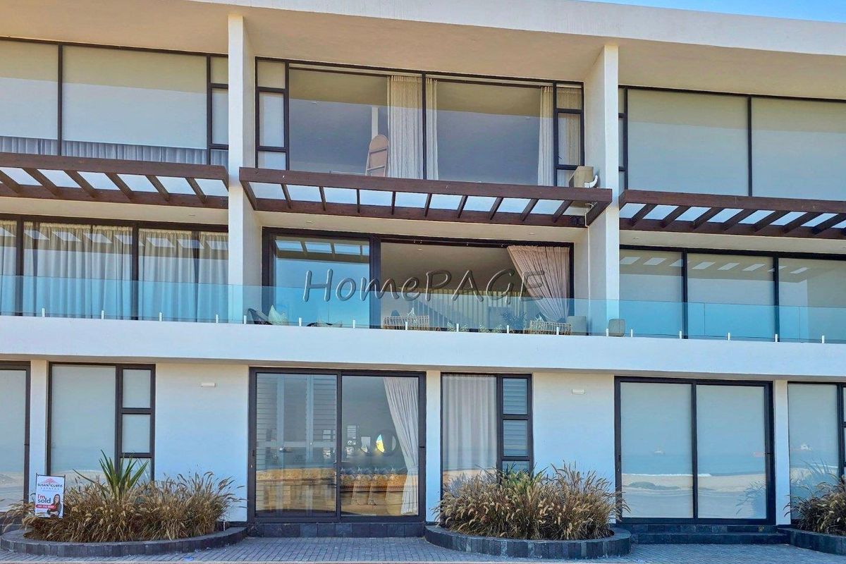 Rear elevation of a modern townhouse featuring multiple levels with glass balustrades, sliding doors, and timber pergola structures overlooking a coastal setting.