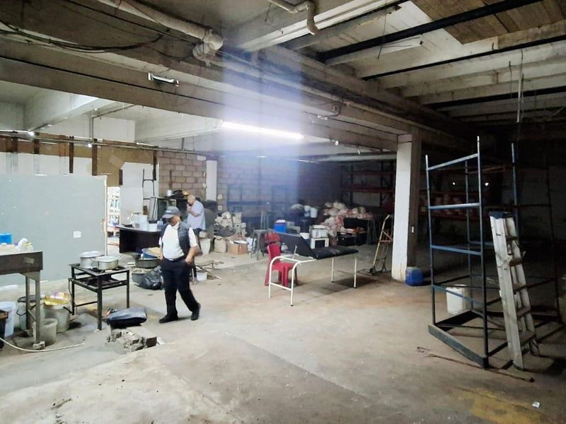 An expansive, unfinished industrial utility space featuring exposed concrete ceilings, structural steel columns, and raw concrete flooring, suitable for various commercial or industrial applications.