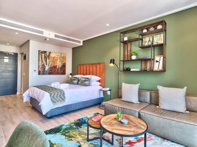 Modern open-plan studio apartment featuring laminate flooring, ducted air conditioning, and contemporary finishes in a well-maintained living and sleeping space.